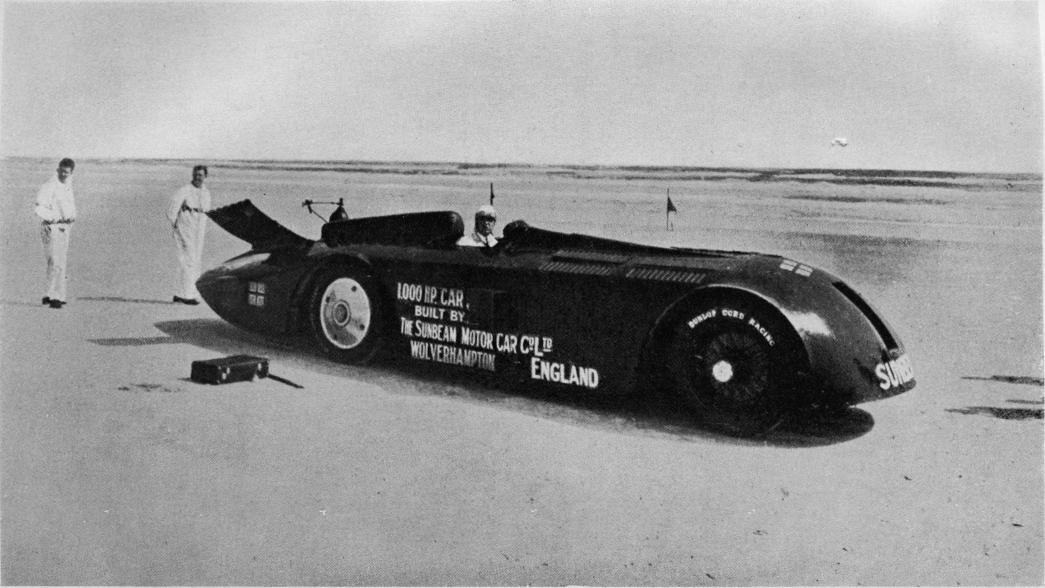 1000-hästkraftersvagnen på sandstranden vid Daytona.<b<smalBakom vagnen stå två av mekanikerna, Lavender och Macdonald.</smal