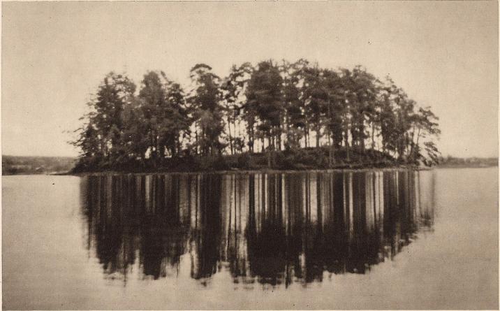 <bHusholmen vid Lidboholm (Ön) i sjön Örken sedd från öster. Pålverket till den långa bron går (under vattnet) till vänster. <bTill höger ligger den lilla Galgholmen, ej synlig å bilden. — Foto: Nils Olsson 1938.