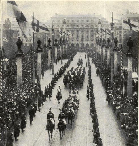 Från kronprinsparets ankomst till Stockholm. Kortégen passerar den med flaggor och kolonner smyckade Norrbro.