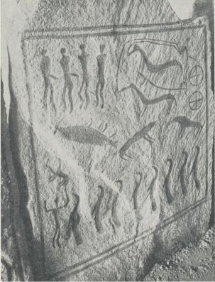 Ena sidohällen i Bredarörs stenkista. Ristningen<båterger en begravningsprocession med (uppe i högra <bhörnet) en solvagn, dragen av ett hästspann, och nederst<ben trupp i fågelhamn utklädda präster, som ledas av<ben mansperson med upplyfta händer. Ena sidohällen i Bredarörs stenkista. Ristningen<båterger en begravningsprocession med (uppe i högra <bhörnet) en solvagn, dragen av ett hästspann, och nederst<ben trupp i fågelhamn utklädda präster, som ledas av<ben mansperson med upplyfta händer.