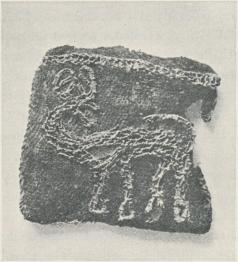 Vävnadsfragment från en av Birkas gravar<b(jfr föreg. bild). Hjortbilden är broderad<bmed guldtråd på ett underlag av siden.